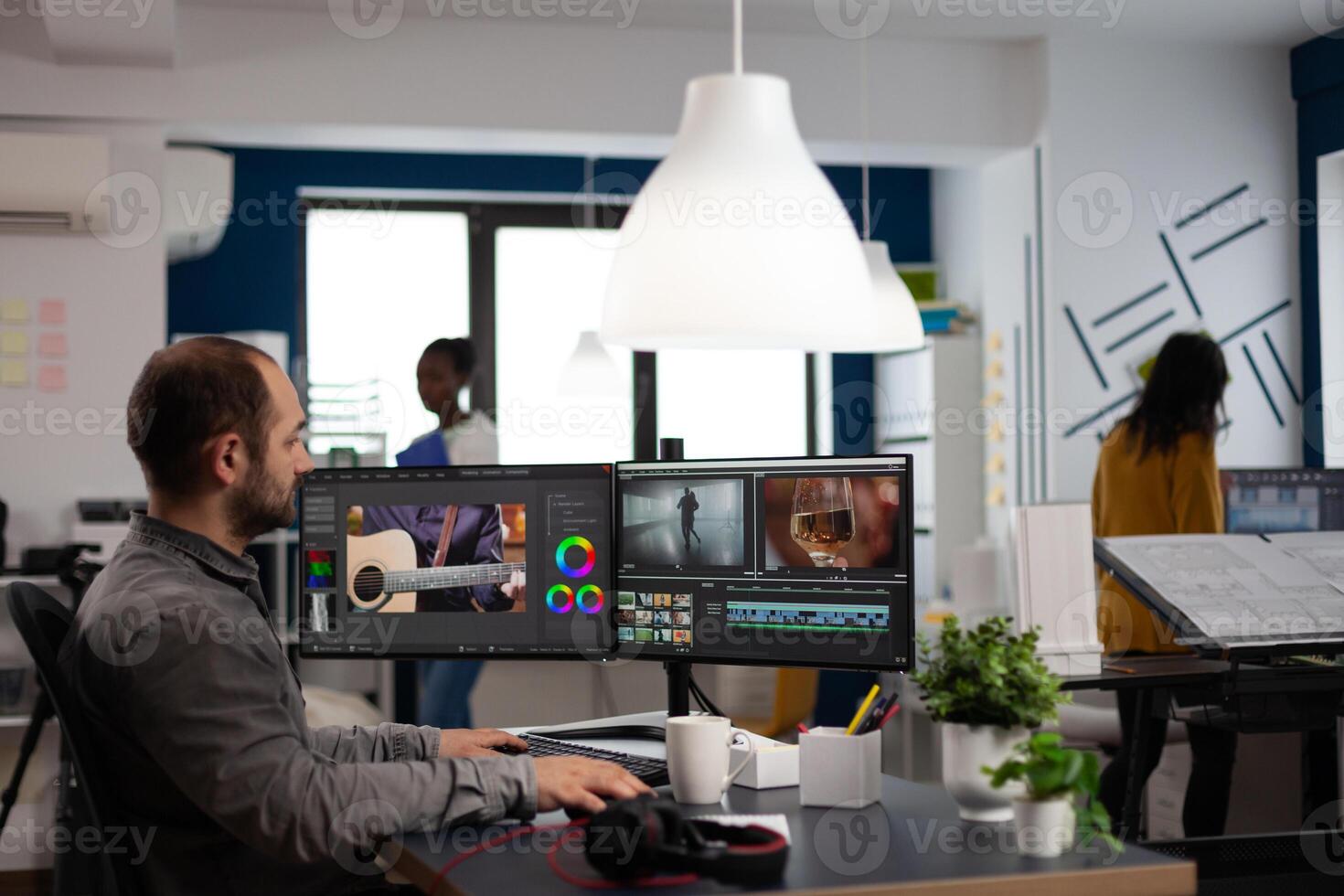 editor cuting footage working at film editing montage on computer with dual monitors setup in multimedia creative agency office. Videographer man processing film using post production software photo
