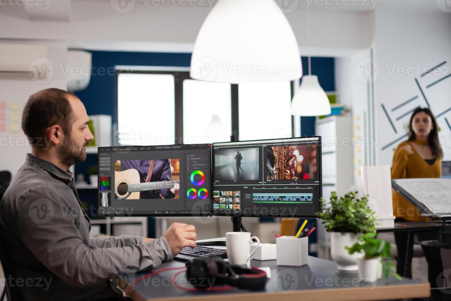 editor man editing movie project working in start up creativity multimedia agency office sitting at pc with two monitors. Editor processing film montage using post production software photo