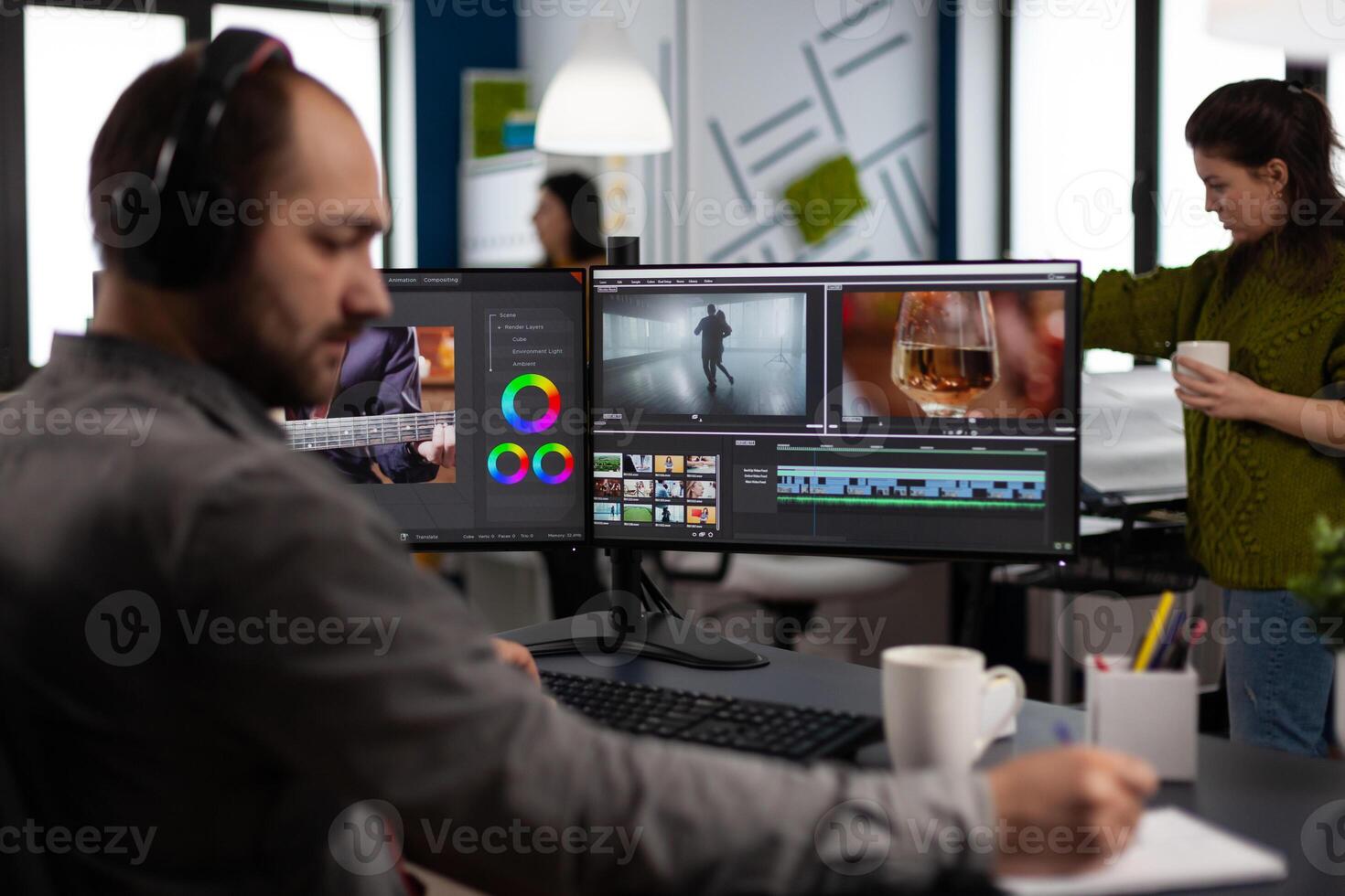 maker with headset working with footage and sound on pc with two displays, taking notes while editing customer creative . Man editor processing film montage in startup agency office. photo
