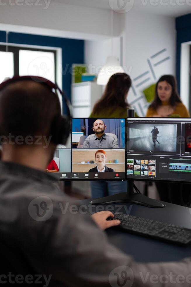 Senior editor director talking with creative team in web online meeting on call editing client footage work. Man getting feedback on movie using post production software on pc photo