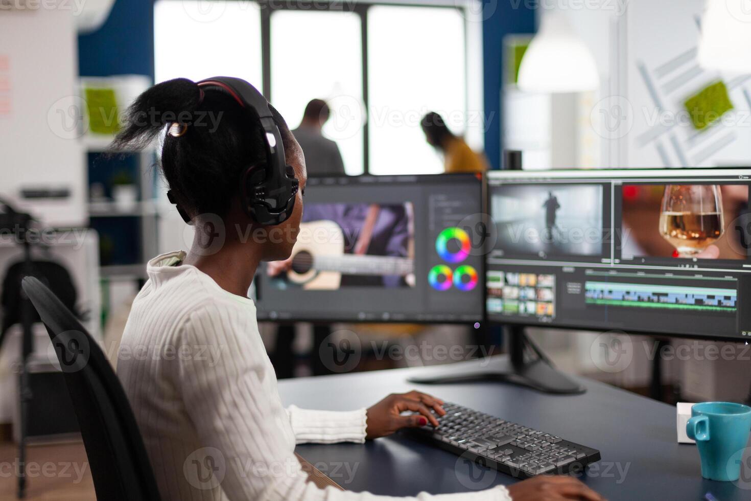 Black woman editor working at project film montage sitting in modern creative agency office. Videographer in digital multimedia company editing movie with post production software photo