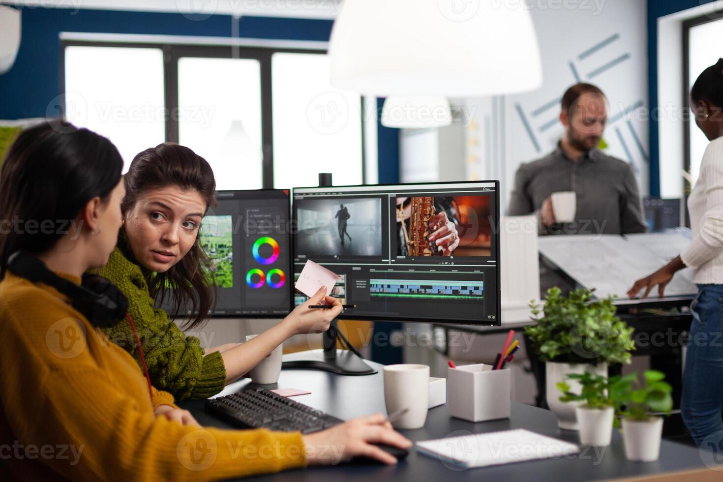 Team of editors women working with modern studio post production software in digital multimedia company. maker employees editing film montage in creative agency looking at computer photo