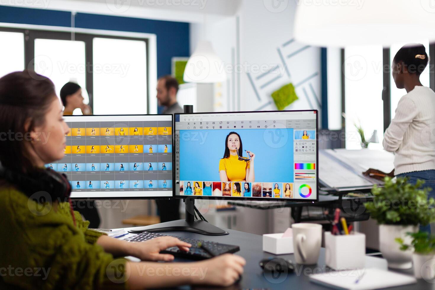 Photographer retoucher woman working on computer with photo editing software. Professional graphic editor retouching assets of client with stylus pencil and two monitors in creative production company