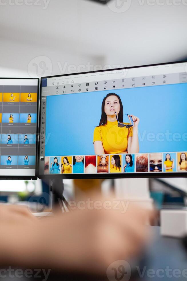Close up of woman editor retoucher holding stylus pencil moving on graphic tablet editing digital photo using computer with two displays. Photographer retouching assets in production agency