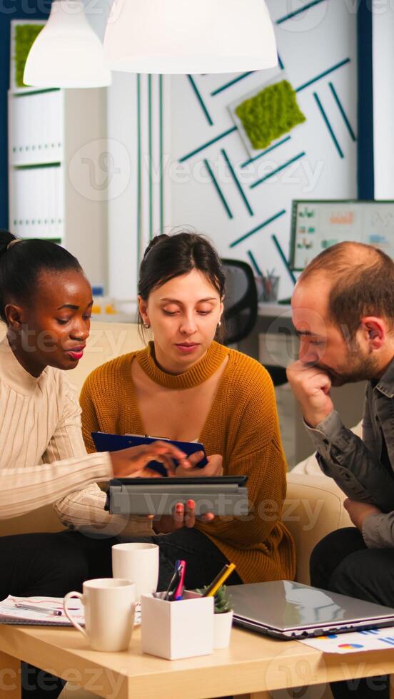 Black Businesswomen shaking hands with manager sitting on couch during business meeting. Diverse business people planning partnership deal discussing project steps for new start-up company. photo