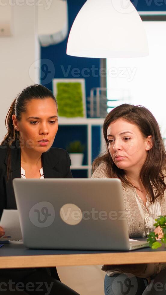 Manager office and creative director working in modern office using laptop sitting at desk developing startup idea. Diverse team of business people analyzing company financial reports from computer photo