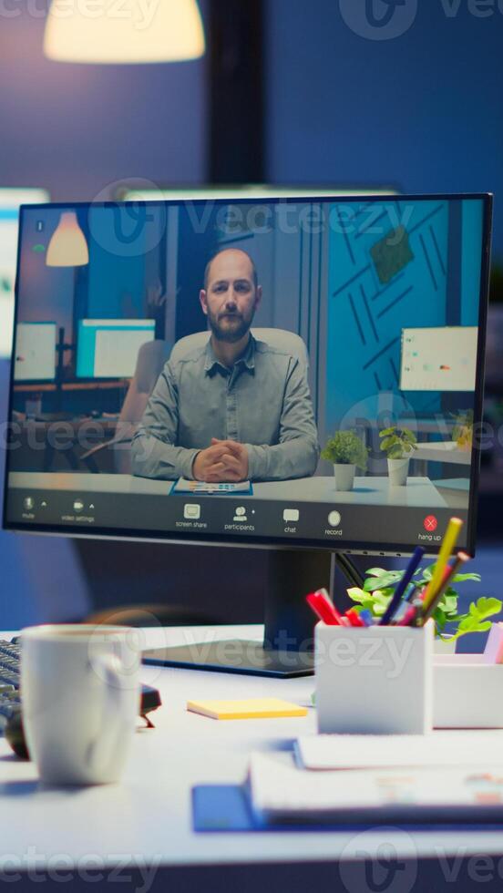 Woman freelancer discussing with client on call at midnight from business office using headphone. Corporate team using group conference technology talking on webcam during online meeting photo