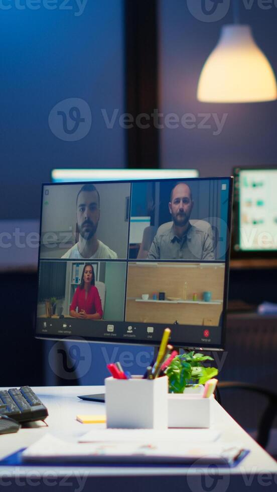 Businesswoman talking during conference with team in midnight using pc in start up business office. Corporate meeting using technology network wireless discussing on webcam late at night photo