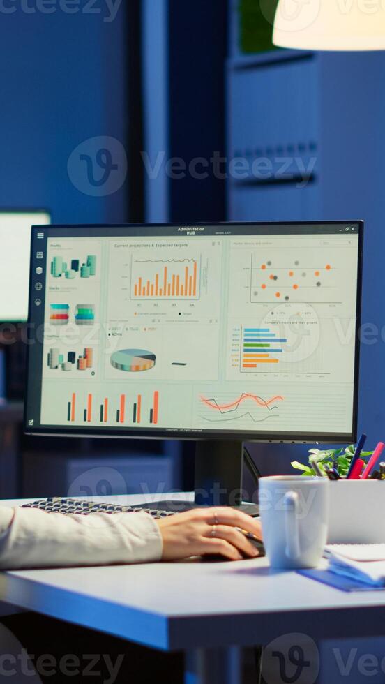 Manager woman working late at night in business office for deadline project checking annual statistics of company. Focused employee using modern network technology doing job overtime photo