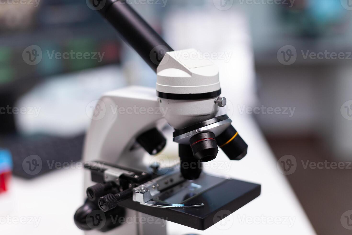 Close up of microscope in microbiology laboratory at science clinic. Scientific instrument with magnifying glass lens and transparent tray for liquid examination in research cabinet photo