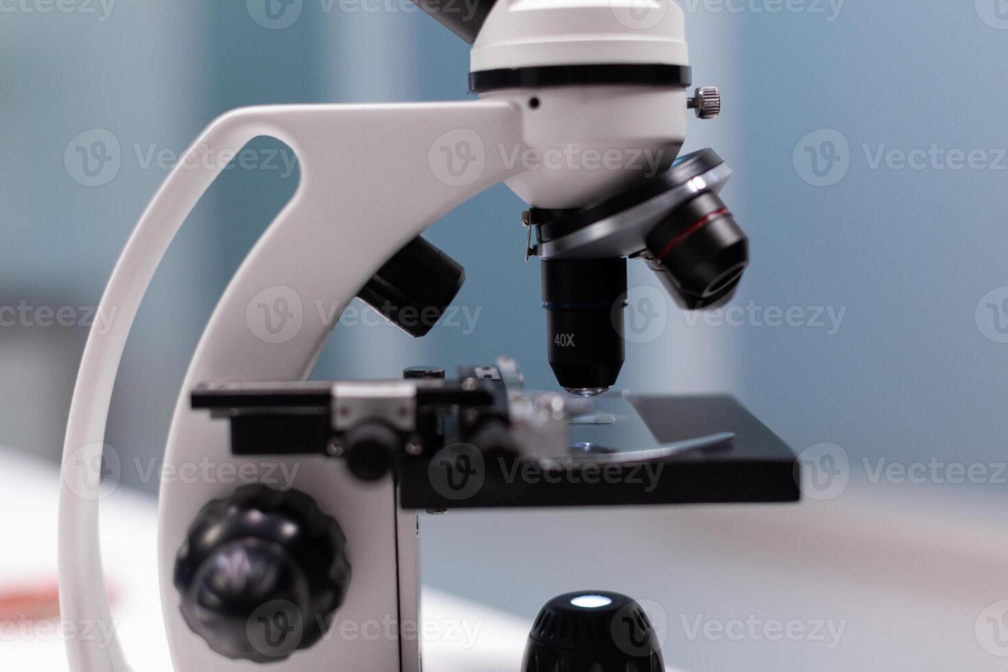 Close up of chemical microscope with magnifying glass for microbiology experiment and development in science laboratory. Instrument with lens and glass tray for dna sample analysis photo