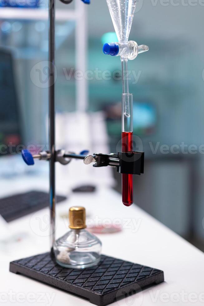 Science laboratory equipment and test tube with blood for healthcare development. Chemical dripping pipe with glass flask for examination in microbiology lab at clinic. Professional instruments photo