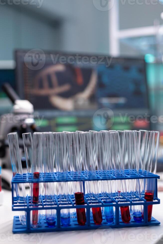 Close up of tube rack with test tubes on laboratory desk. Transparent lab glassware with liquid blood, dna and solution prepared for research analysis in microbiology industry space photo