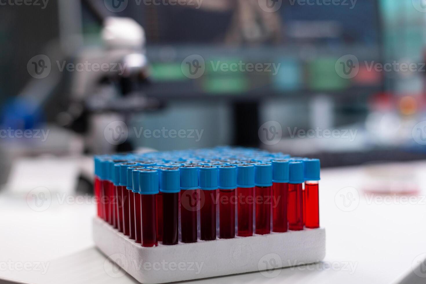 Close up of tray with vacutainers on laboratory desk. Chemical transparent tool with blood in test tubes for research development in microbiology cabinet with scientific equipment photo
