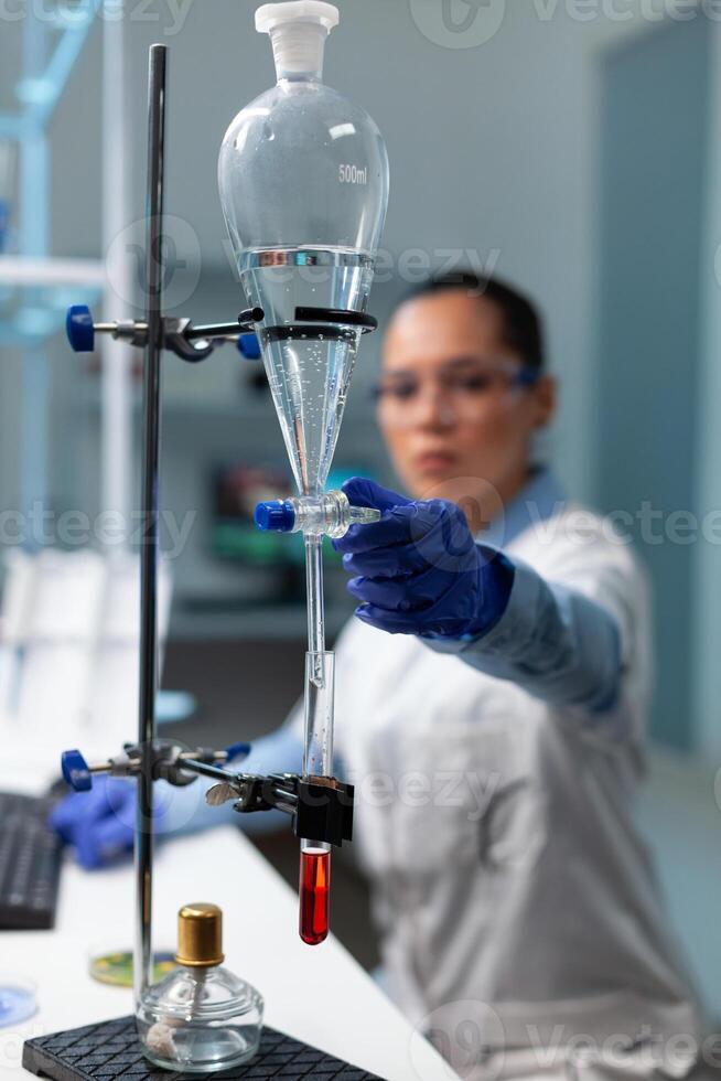 Selective focus on medical transparent equipment standing on table in microbiology hospital laboratory. Scientist woman doctor working at healthcare treatment against virus disease photo