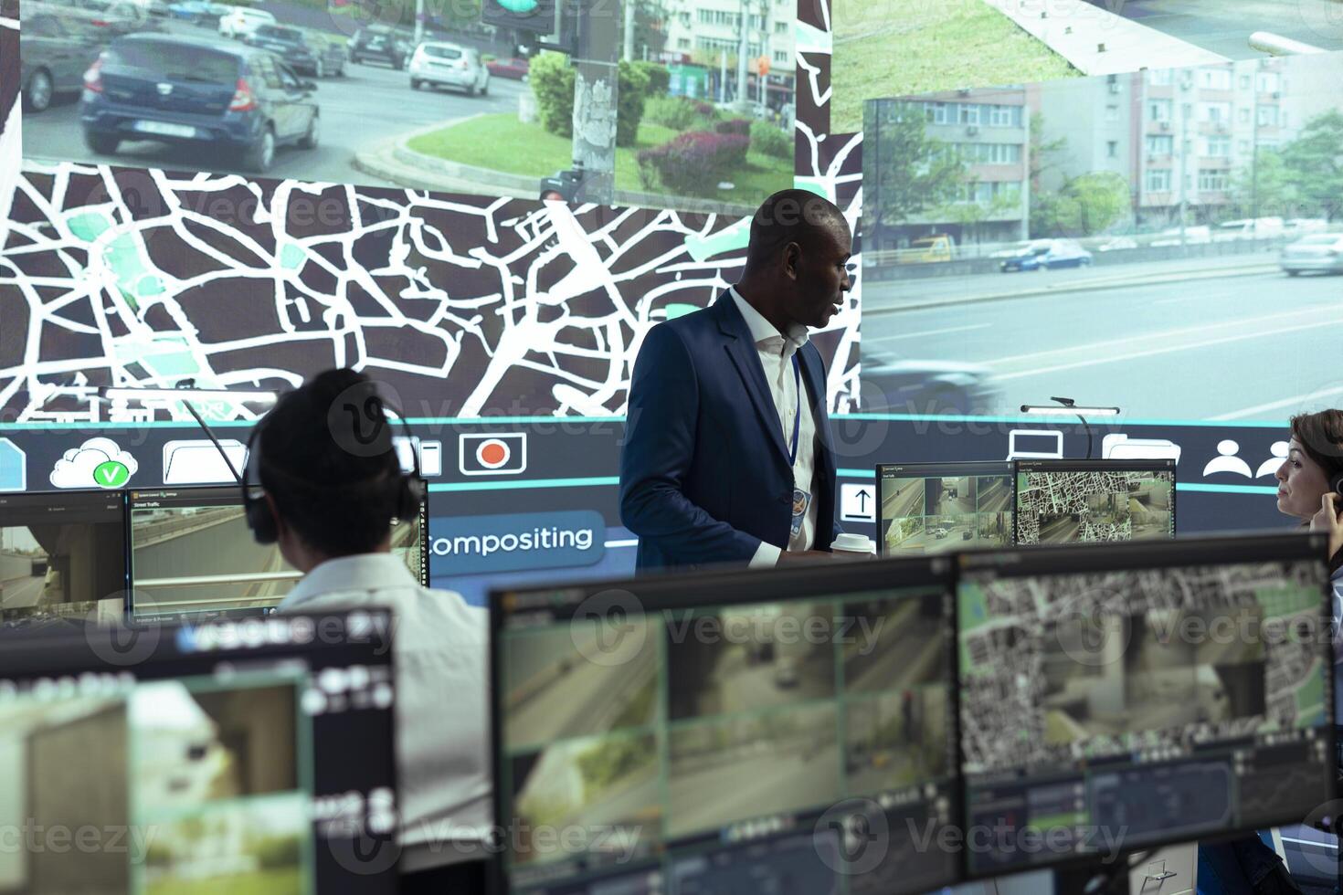 African american supervisor managing his team in control center at shipping agency headquarters, overseeing shipping activities to ensure order and parcel delivery. Working with satellite maps. photo