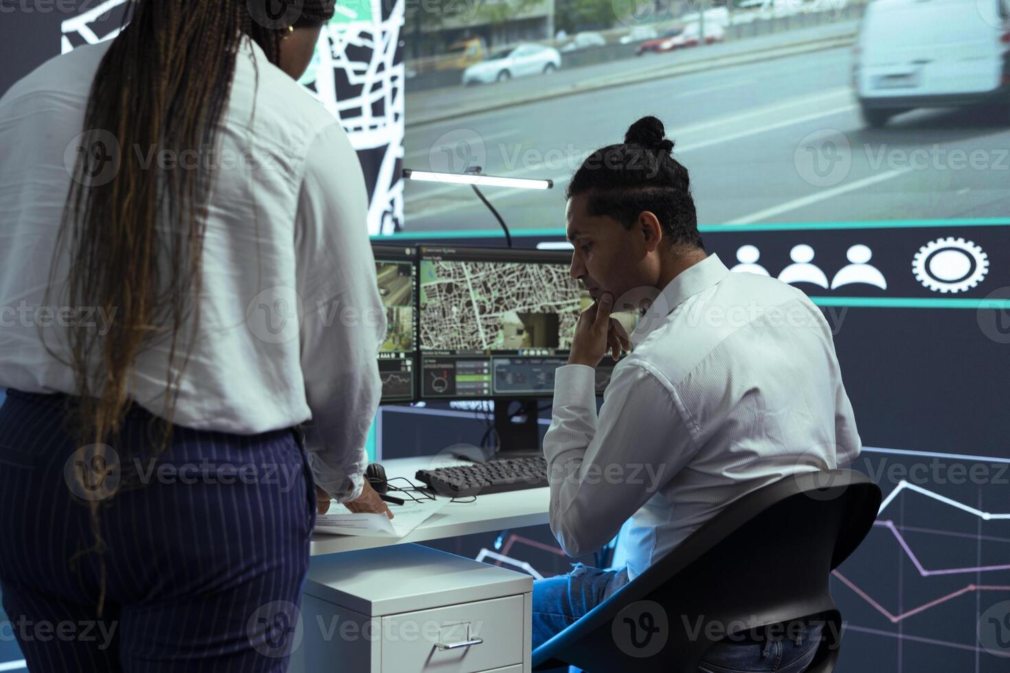 Indian employee consulting his african american team leader on cargo logistics insight, discussing about improving express shipment by using gps coordinates on satellite map, order tracking. photo