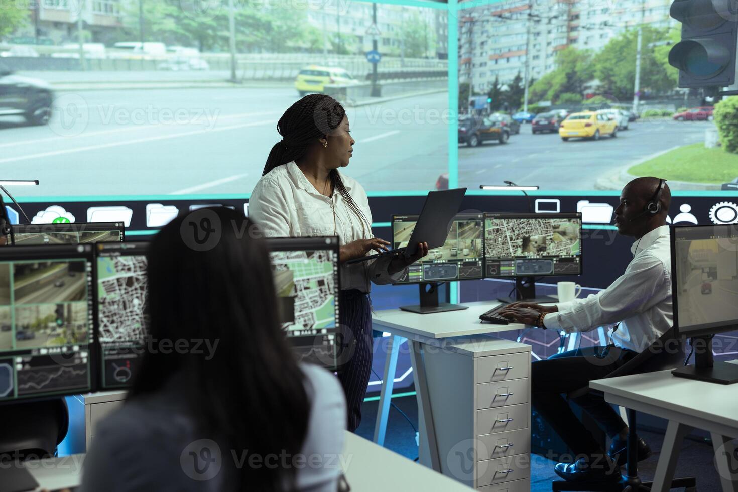 Diverse employees monitoring urban traffic in control center agency, following cars and their license plate data through surveillance and CCTV networks. Government radar sensors. photo