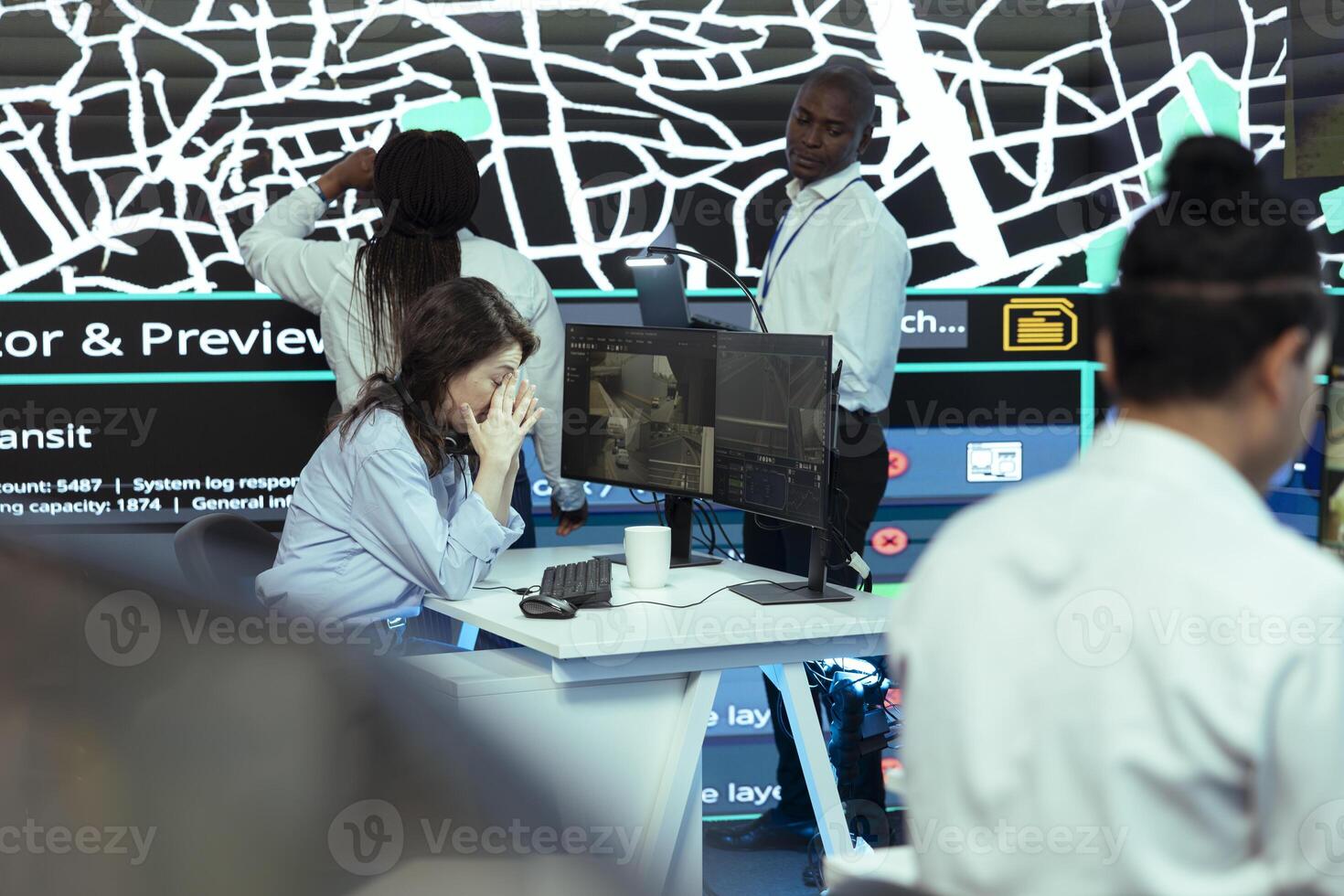 Sleepy frustrated woman monitoring and locating couriers in traffic, guiding delivery truck drivers via gps tracking on satellite and radar navigation. Employee works on express shipping. photo