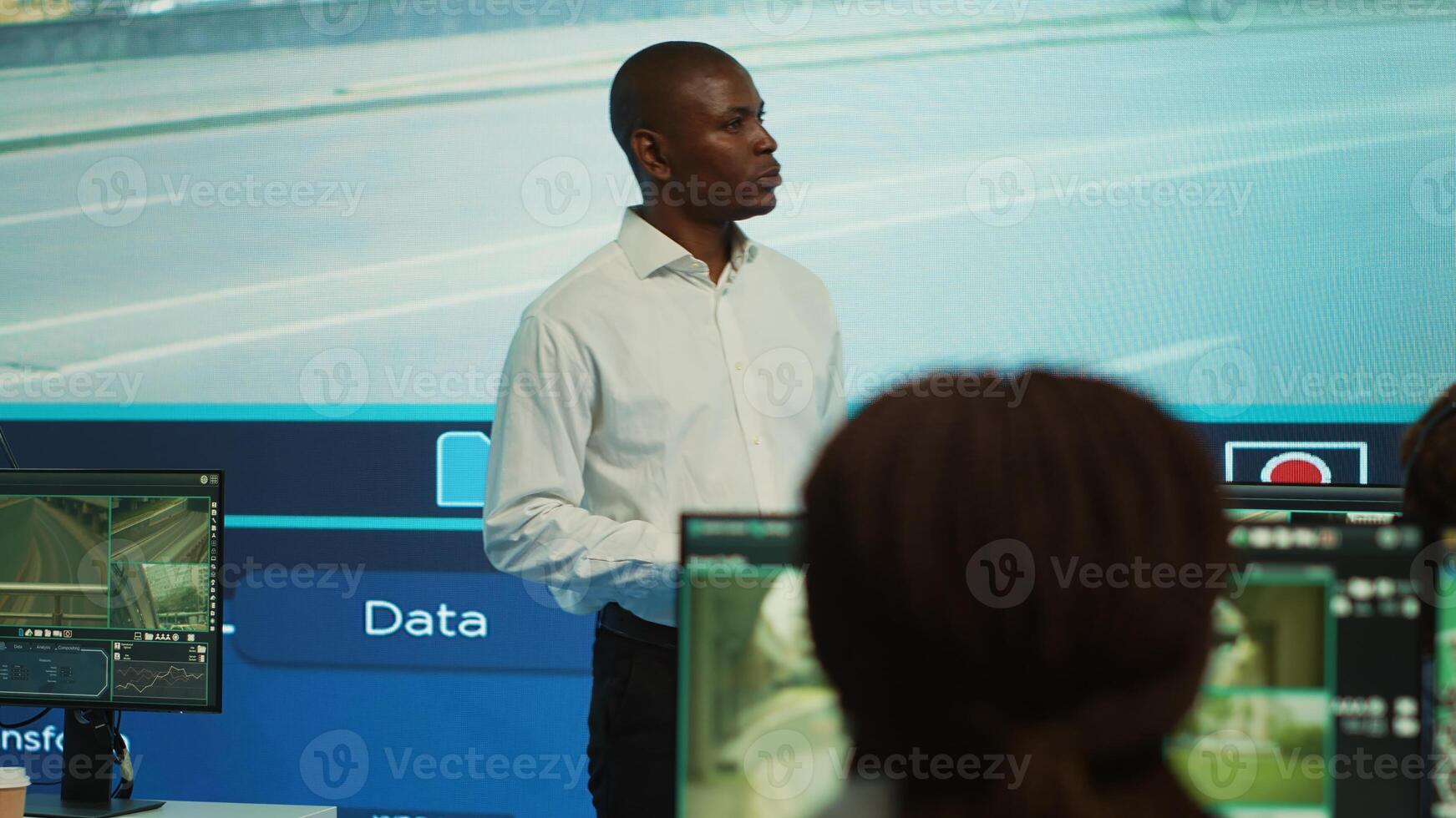 Team leader supervising his employees monitoring the traffic, diverse people employing surveillance camera in the city. Control center tracking radar footage via CCTV security system. Camera A. photo