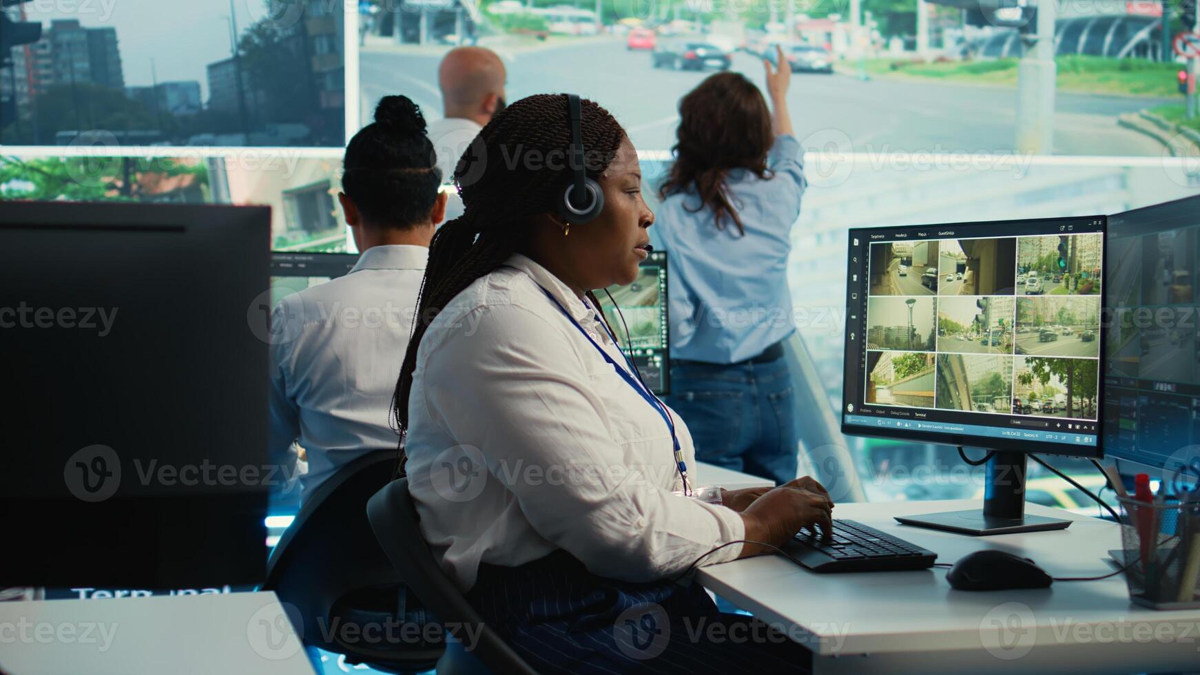 African american employee monitoring traffic activity in the city by using CCTV system to ensure public safety. Woman watches real time surveillance footage in government observation room. Camera B. photo