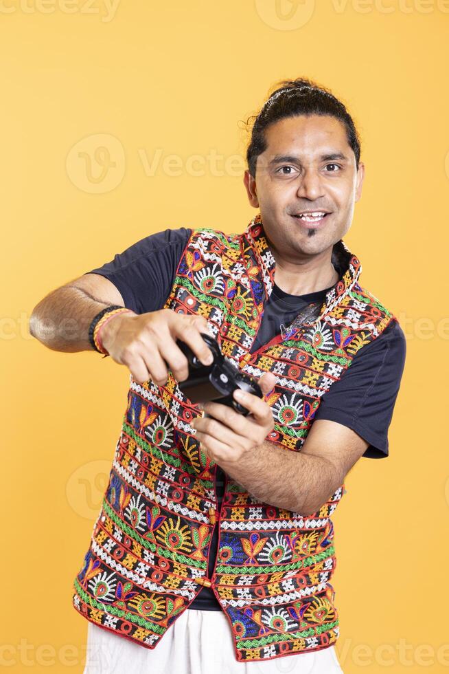 Portrait of focused gamer holding controller, concentrating on finishing videogame level. Man pressing gamepad buttons, spamming attacks, solving quests, isolated over studio backdrop photo