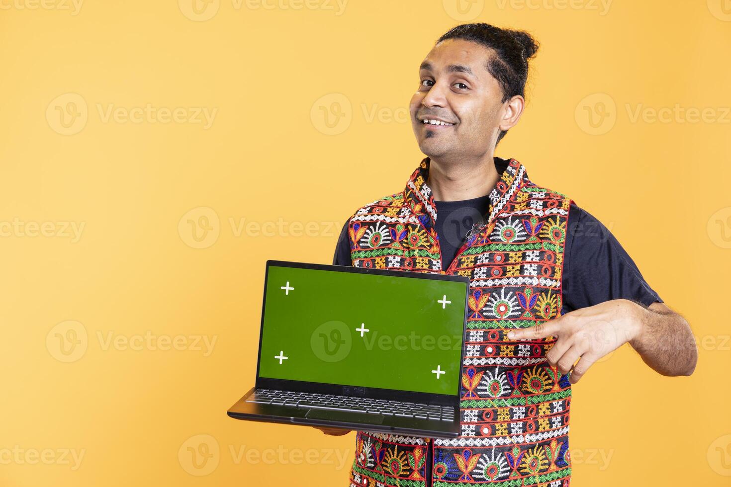 Portrait of joyful man presenting isolated screen laptop, studio background. Cheerful person smiling and pointing finger towards mockup notebook used for advertising brands photo