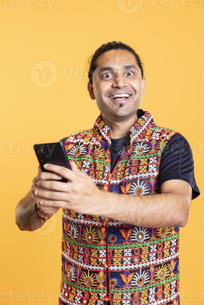 Portrait of overjoyed person using smartphone, having positive surprise facial expression after seeing picture on social media feed. Astonished man holding mobile phone, relaxing, feeling ecstatic photo