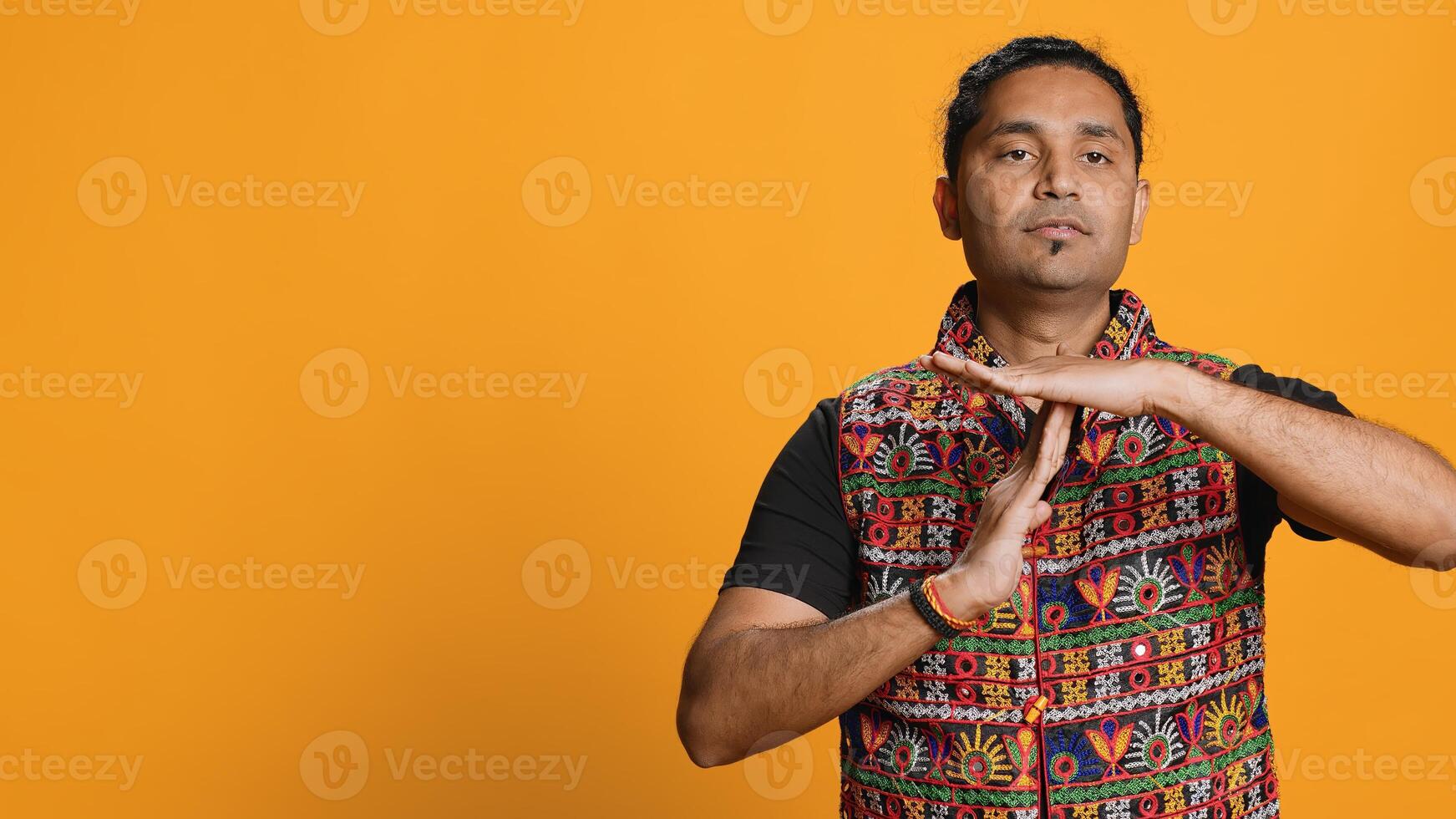 Serious man requesting timeout, doing hand gestures, unable to continue concept. Bold person doing insistent pause sign gesturing, desiring break, isolated over studio background photo
