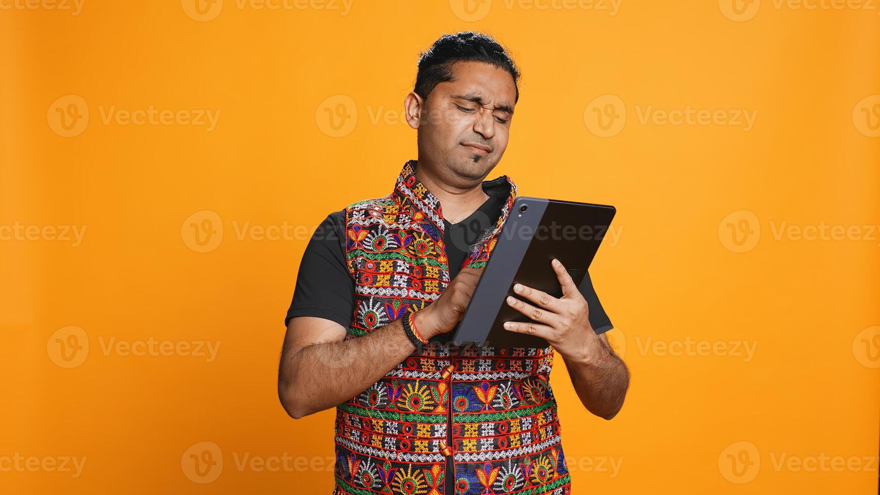 Man upset after lacking necessary money while trying to buy stuff online on tablet. Sad person looking at debit card after getting transaction rejected on device, studio background, camera B photo