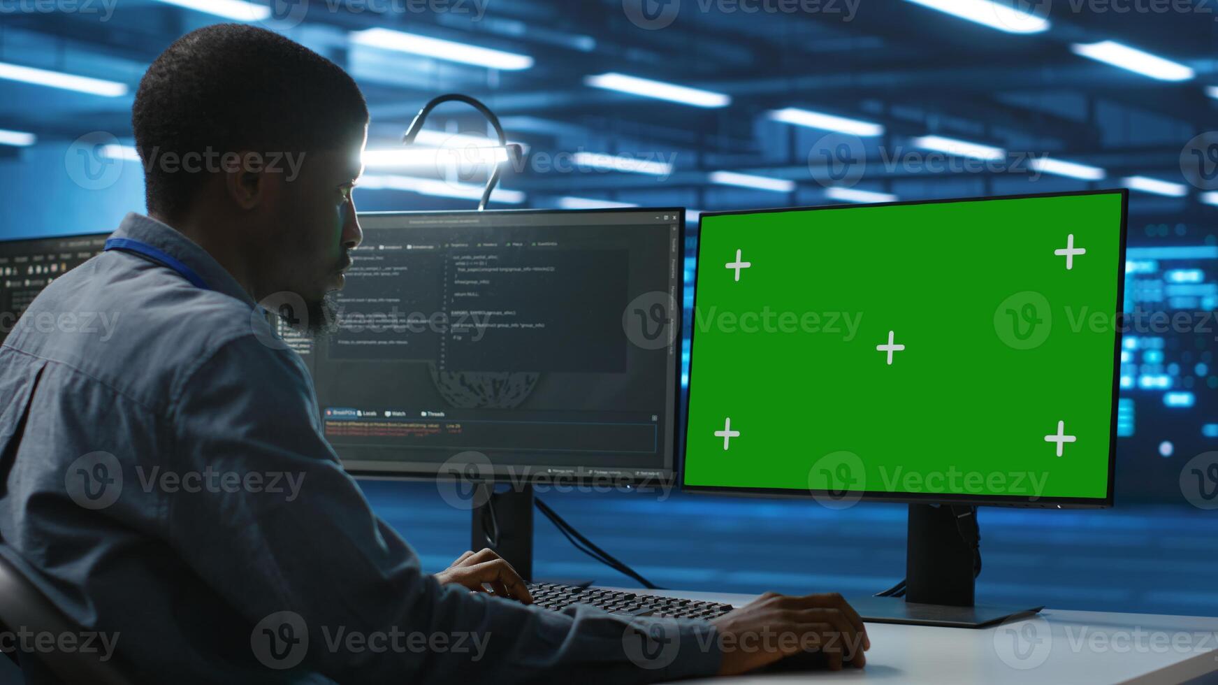 Employee working on green screen computer in server hub capable of processing vast amounts of data. IT developer at typing at chroma key PC, updating servers controlling network resources photo
