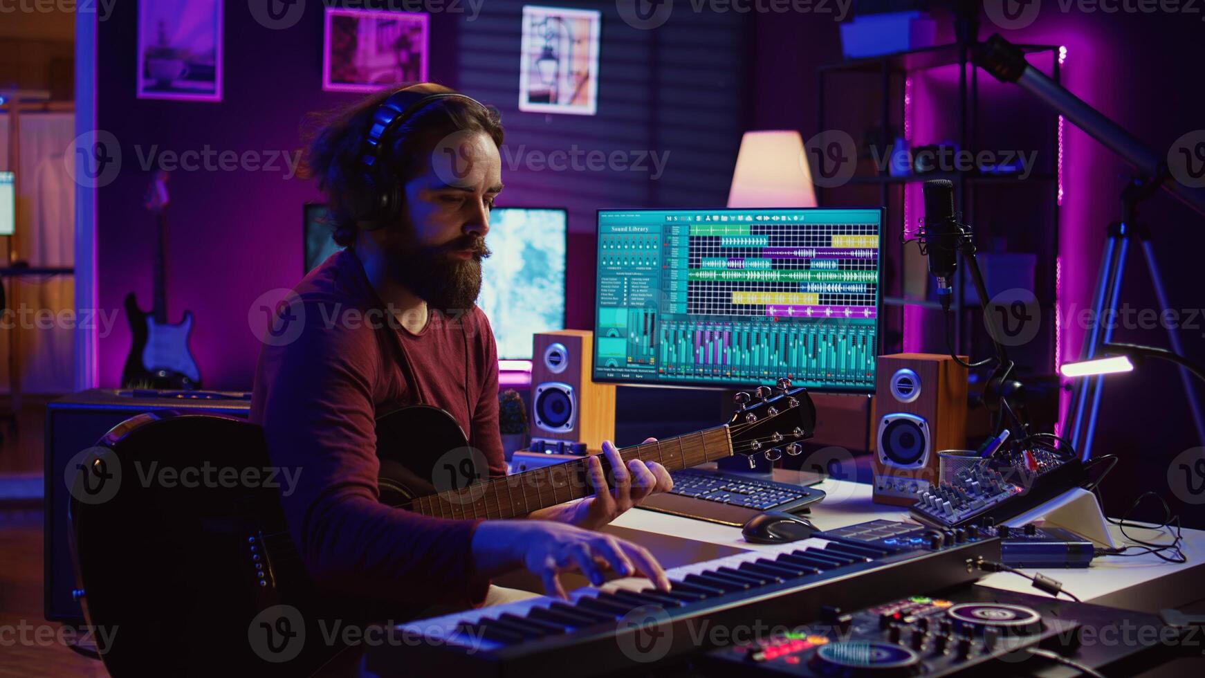 Musical composer recording his guitar tunes and adding piano key sounds, creating a beautiful song with mixing console and daw software. Sound engineer working with electronic tools. Camera B. photo
