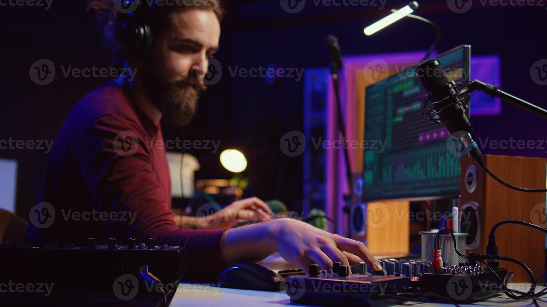 Sound engineer recording and producing audio for music industry, operating on mixing console and daw software in home studio. Musician ensuring optimized acoustics, mastering tracks. Camera B. photo