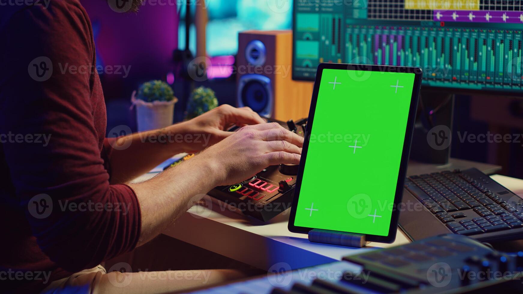 Music producer songwriter mixing tunes on stereo console, recording sounds next to tablet with greenscreen layout. Artist using equalizer and control panel board, daw software. Camera A. photo