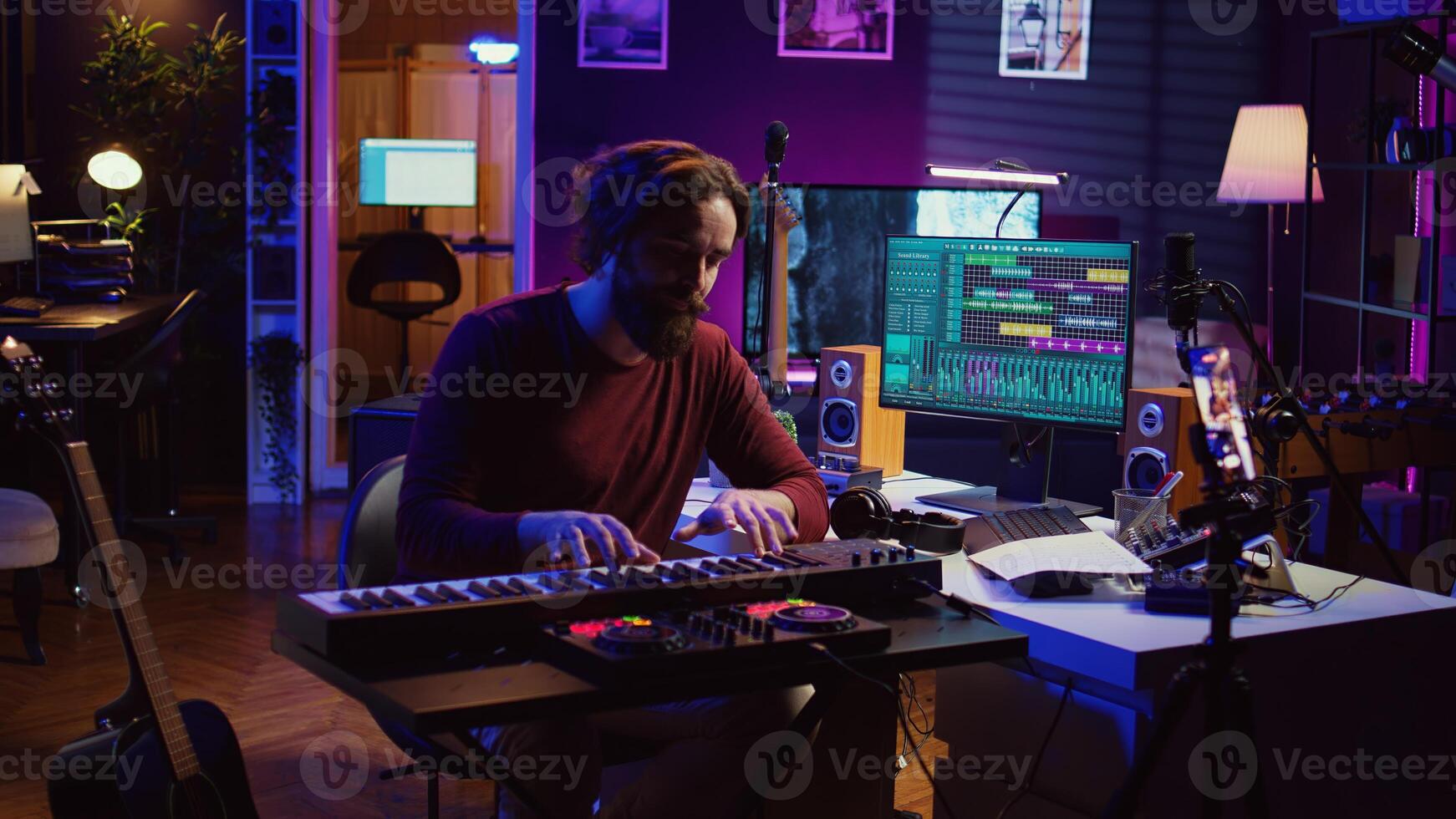 Artist teaching online piano lessons from his home studio, recording tutorial and playing midi controller synthesizer. Instructor explaining electronic keyboard notes, music industry. Camera B. photo