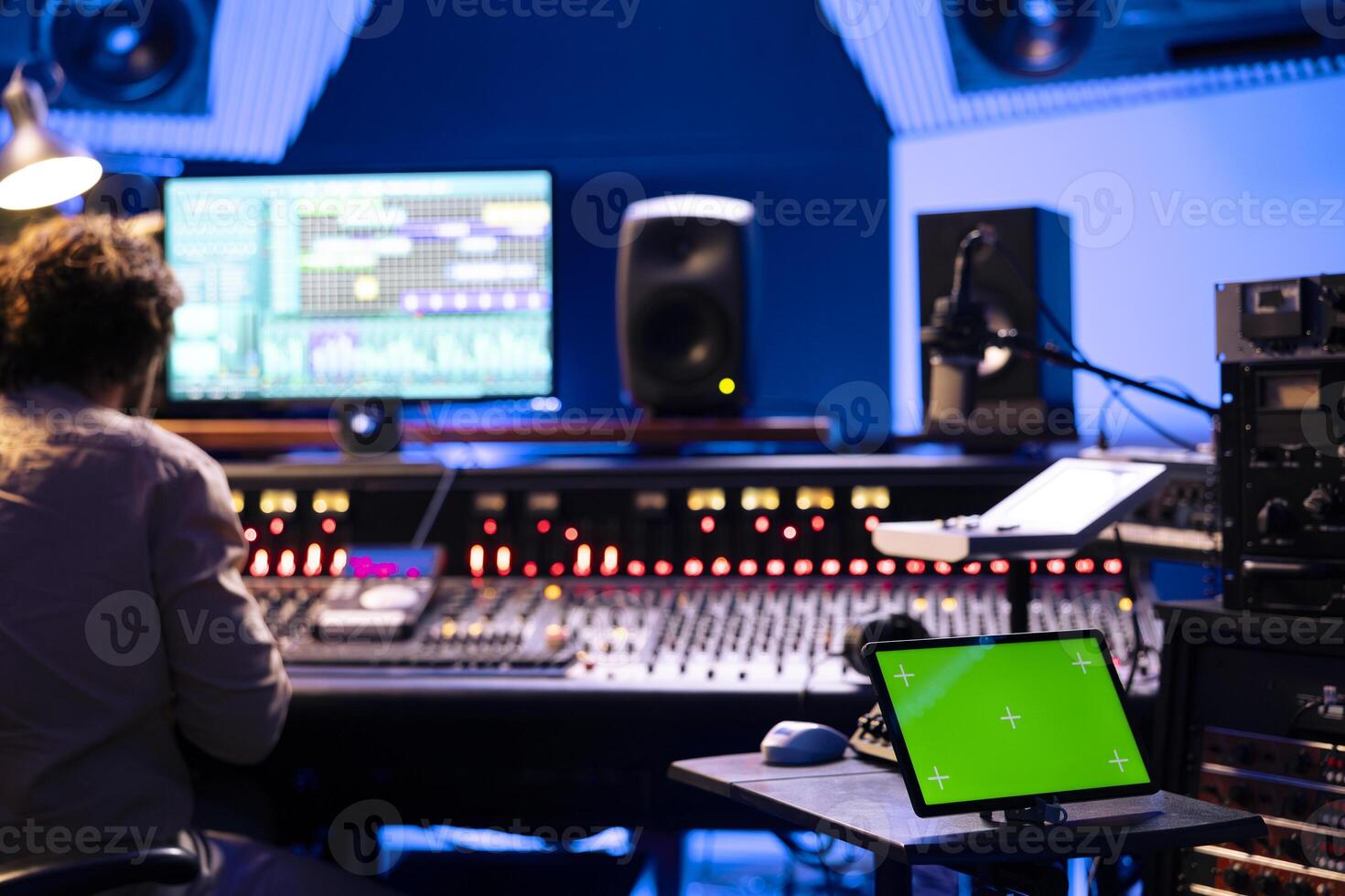 Device with mockup screen in control room at professional studio, audio technician producing and recording music with panel board buttons or sliders. Producer editing tracks with stereo gear. photo