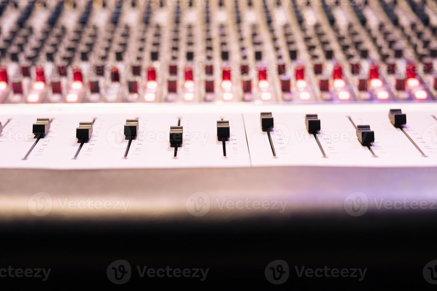 Control panel board desk with sliders and motorized faders in professional recording studio, mixing console used in editing records. Switchers, knobs and buttons used in production. Close up. photo