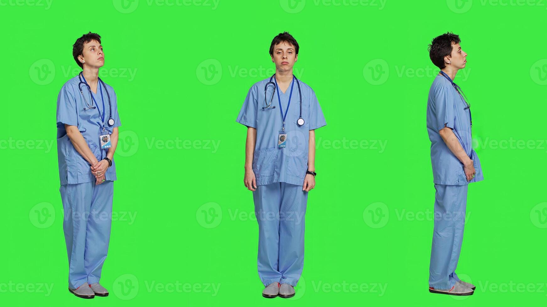 Displeased nurse saying no and sighing against greenscreen backdrop, acting disappointed while she wears blue scrubs. Medical assistant with expertise shows negative gesture, being tired. Camera A. photo
