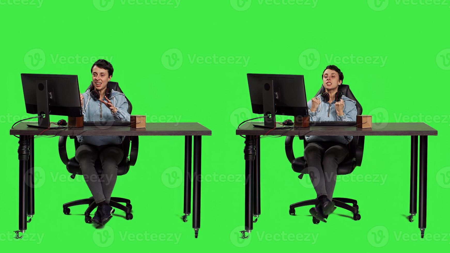 Young adult playing games on computer and winning round, celebrating success and feeling pleased. Woman enjoys online pc shooter championship against greenscreen backdrop. Camera A. photo