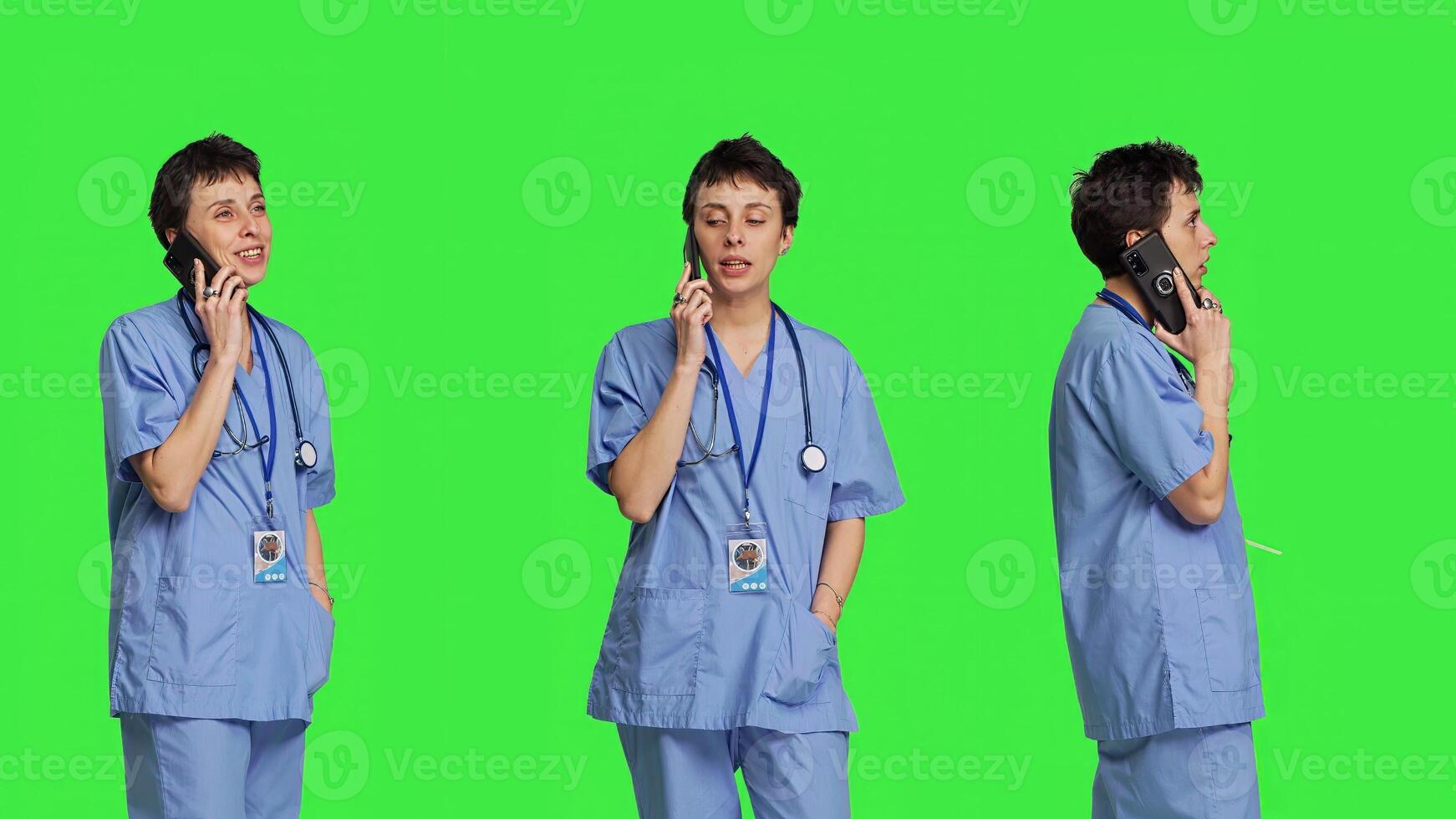 Health specialist using smartphone to make important calls, standing against greenscreen backdrop. Nurse talking to patients for checkup exams on telephone line, calling people to confirm. Camera B. photo