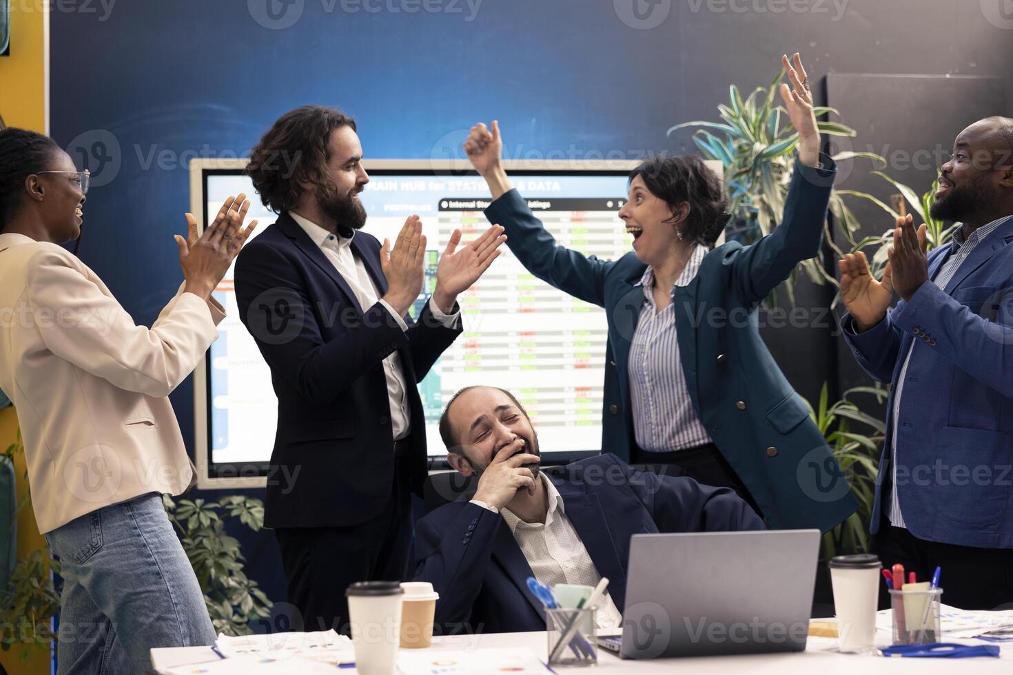 Joyful pleased colleagues celebrating project achievement after looking at sales trends reports, jumping around in the boardroom and feeling proud of their team. Skilled people enjoying success. photo