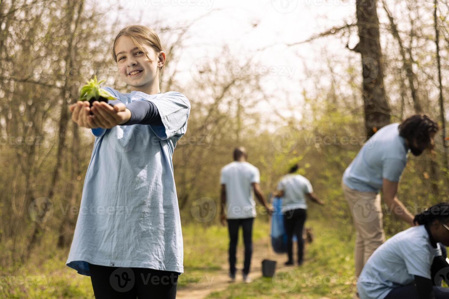 Young kid holding a small seedling before planting it in the woods, being passionate about environmental protection. Presenting a grown tree seed in organic soil, conserving nature. photo