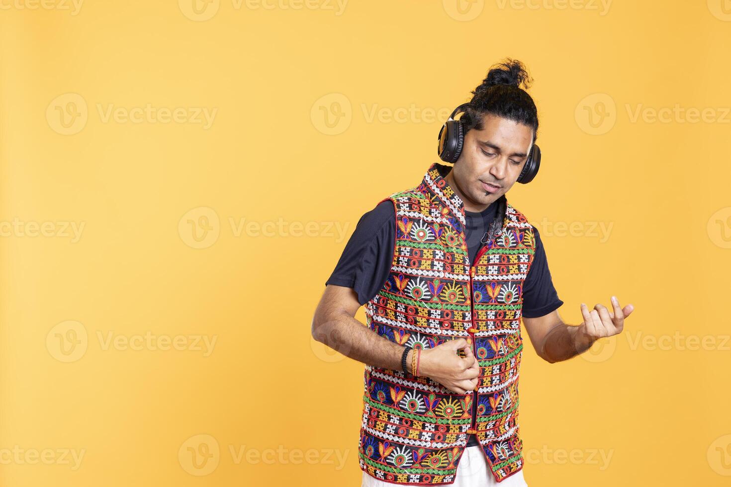 Man with imagination doing air guitar gesturing, playing music, isolated over studio backdrop. Man pretending to use musical instrument to get over boredom, feeling entertained photo
