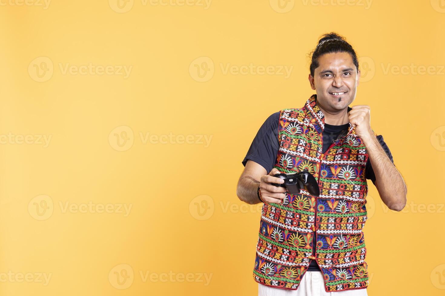 Happy gamer celebrating after winning game on gaming console, studio background. Delighted man bragging after being victorious in videogame, defeating all enemies using gamepad photo