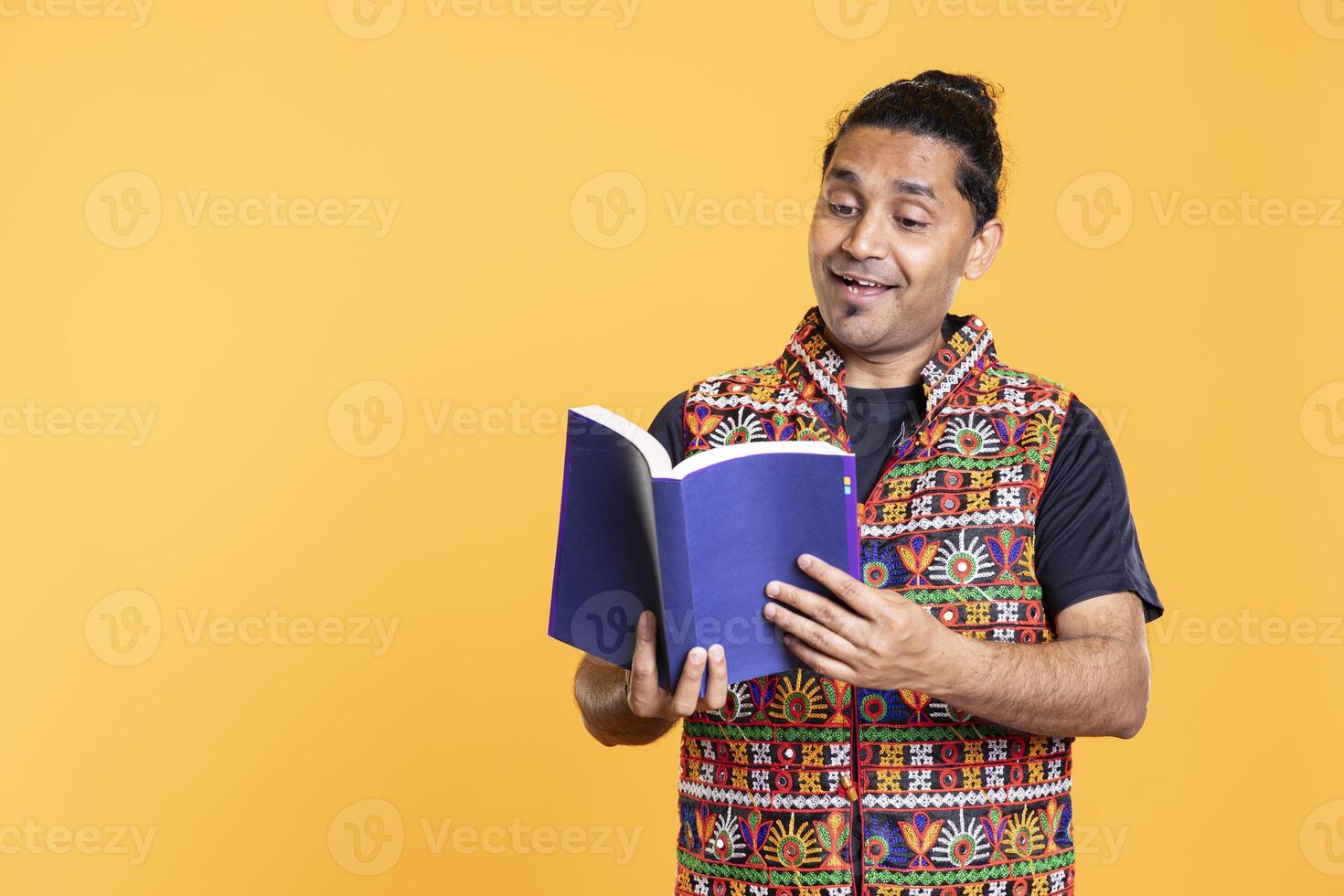 Joyful reading enthusiast delighted to read book, enjoying plot, isolated over studio background. Upbeat person pleased by interesting novel, enjoying leisure time, appreciating literature photo