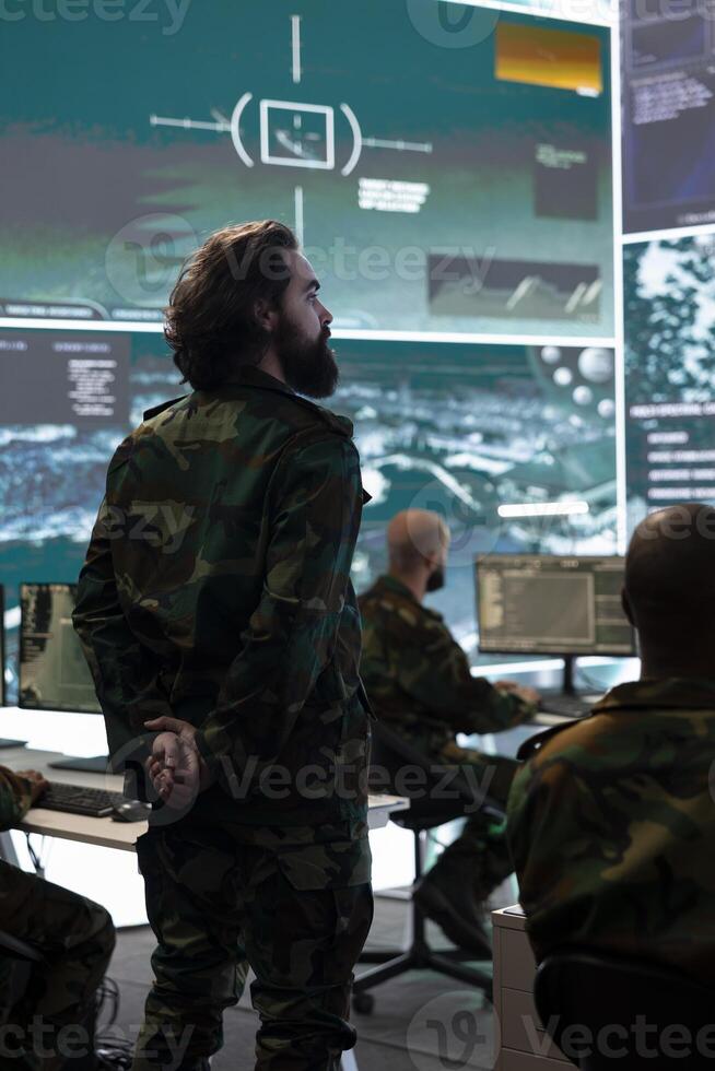 Signal support system specialists providing guidance and crucial battlefield data to the recruits in the field. Military defense program division in power base monitoring room. photo