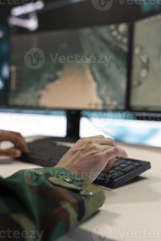 Combat IT engineer supervising and assisting team members in the field via radar surveillance system, guiding his troops in fighting and defensive positions. Sergeant gathers intelligence. Close up. photo