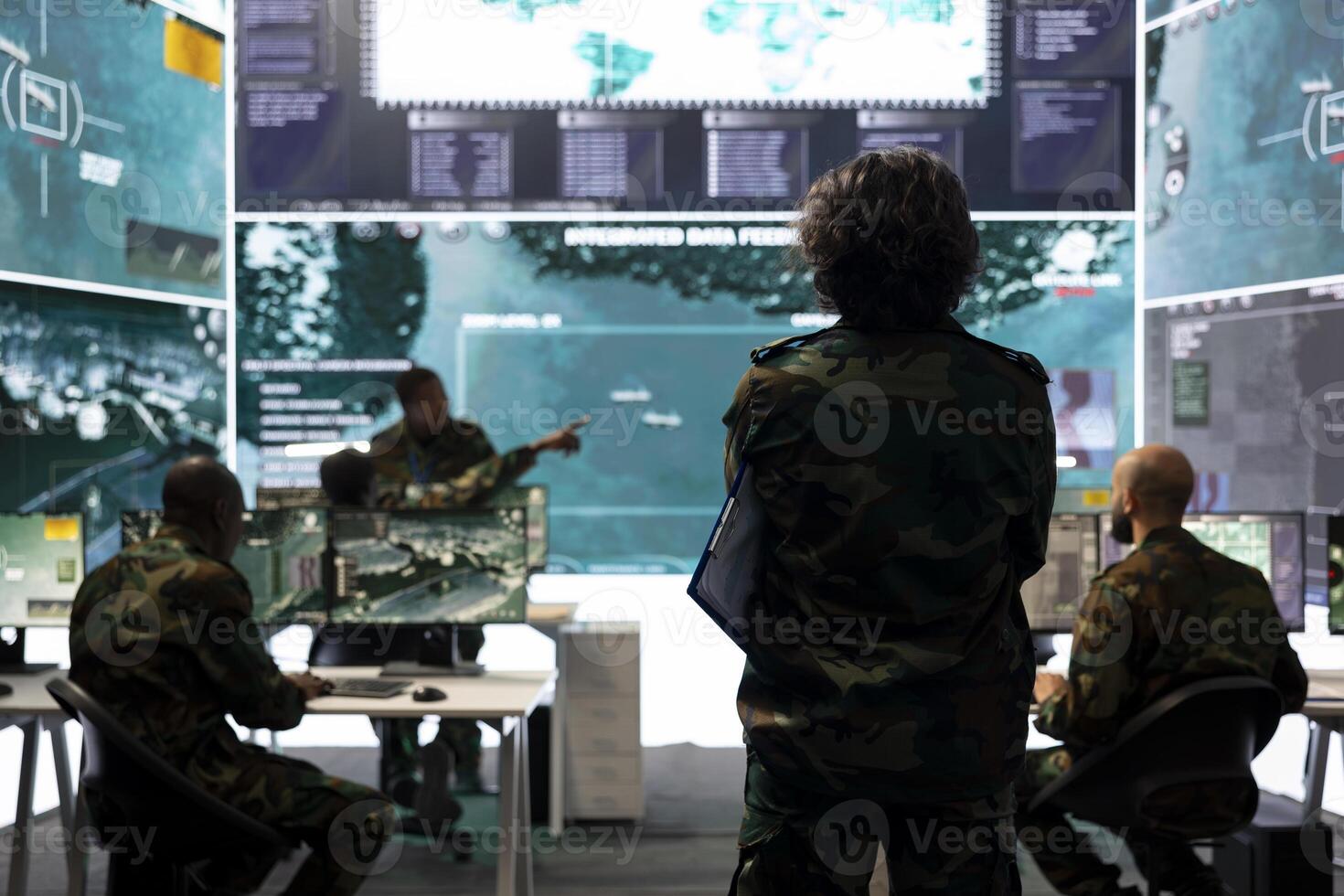 Intelligence analyst supervising and coordinating in the federal data analysis, processing strategic and tactical information to create a new battlefield world map. Military division in control room. photo