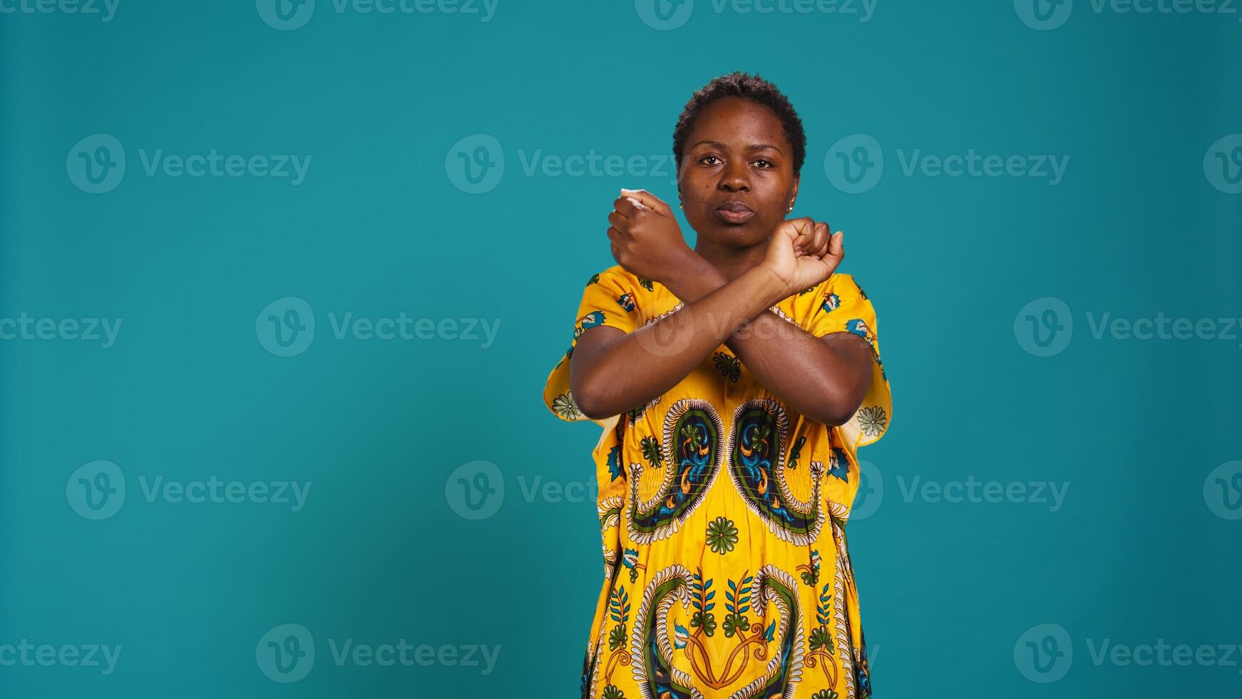 Dissatisfied unhappy person showing a refusal symbol with hands in a stop sign shape, expressing negativity and her rejection for something in studio. Young woman feels displeased. Camera B. photo