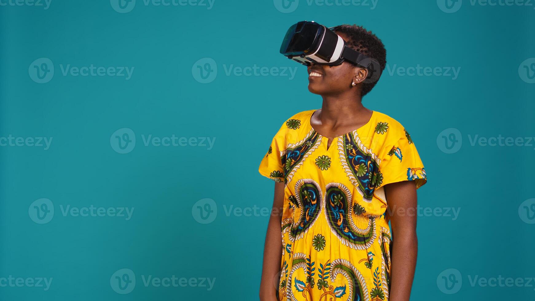 Young happy woman working with a virtual reality headset in studio, using the innovative 3d simulation experience with modern equipment. VR glasses on girl in traditional ethnic clothes. Camera B. photo